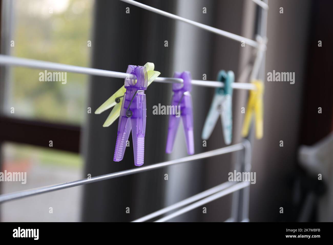 A portrait of multiple washingpins hanging on a laundry rack. The