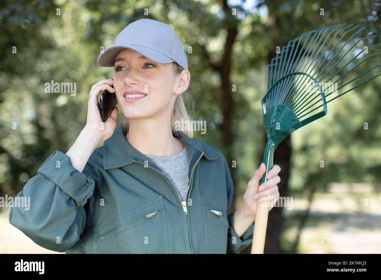 Woman gardener using rake on hi-res stock photography and images - Alamy