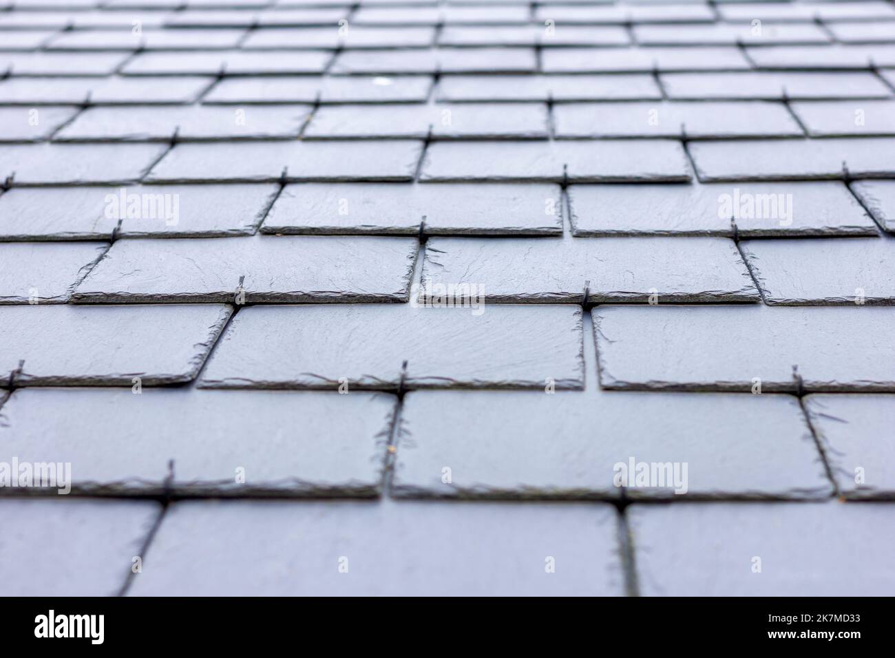 A close up portrait of a black, blue slate tile roof. The long lasting