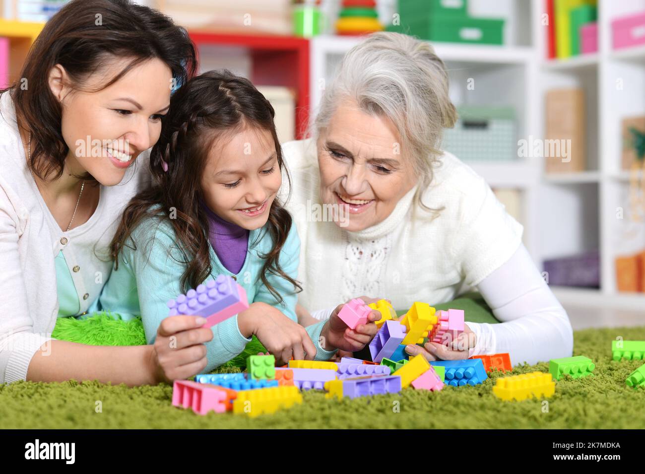 Cute girl playing with mom and grandma in cubes Stock Photo - Alamy