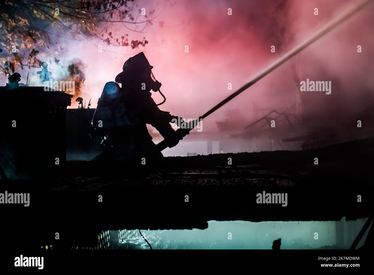 A firefighter operating a hose is silhouetted in the smoke as at 2:43 a.m. on Sunday, October 28th, 2018, members of the Springs Fire Department respo Stock Photo