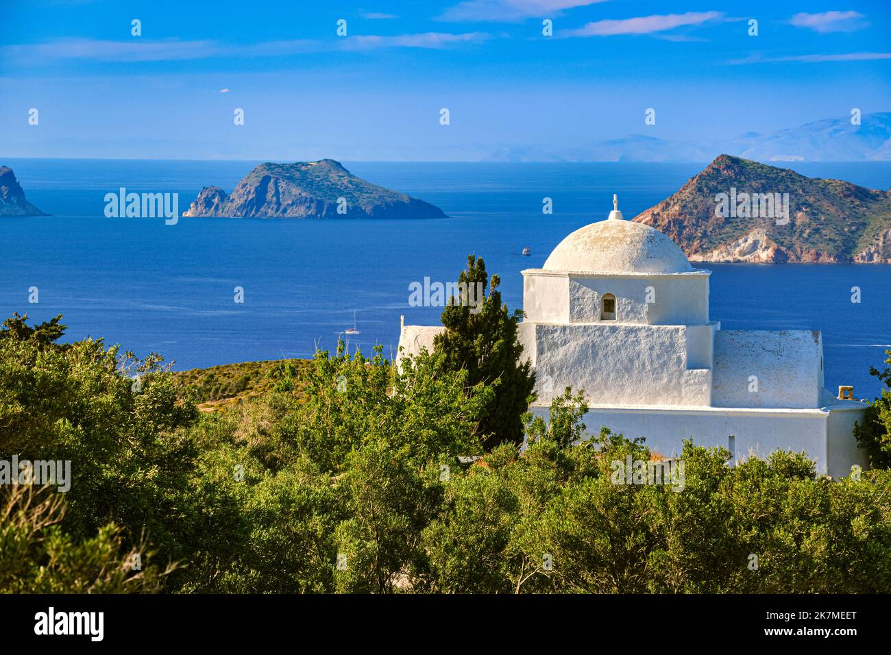 White Greek Orthodox chapel or church on top of hill, clear blue sky, sunny day. Milos, Greece Stock Photo