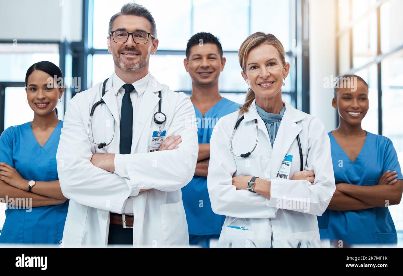 Doctors, nurses and team portrait in hospital, clinic or medical office. Teamwork, diversity and healthcare professionals standing together with arms Stock Photo