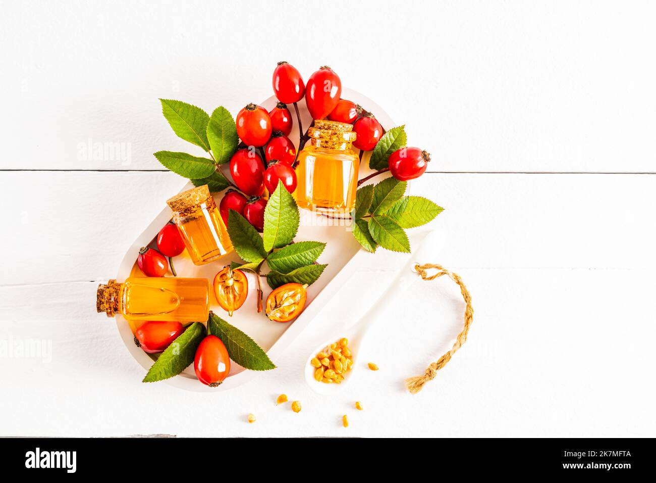 three bottles with a cork with essential oil of rosehip seeds on a ...