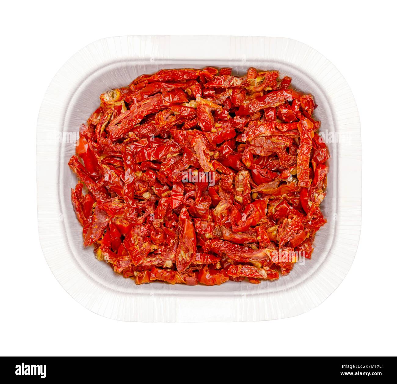 Sun dried tomatoes, in a white punnet, isolated from above. Red ripe plum tomatoes, cut into Julienne strips, salted and then dried in the sun. Stock Photo