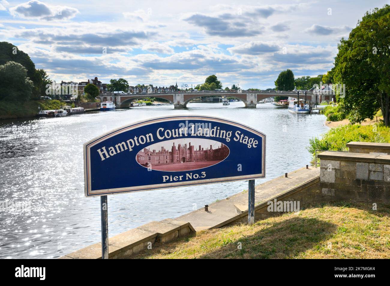 Sign at Hampton Court Landing Stage Pier No 3 with view of Hampton Court Bridge crossing the River Thames, East Molesey, England, UK Stock Photo