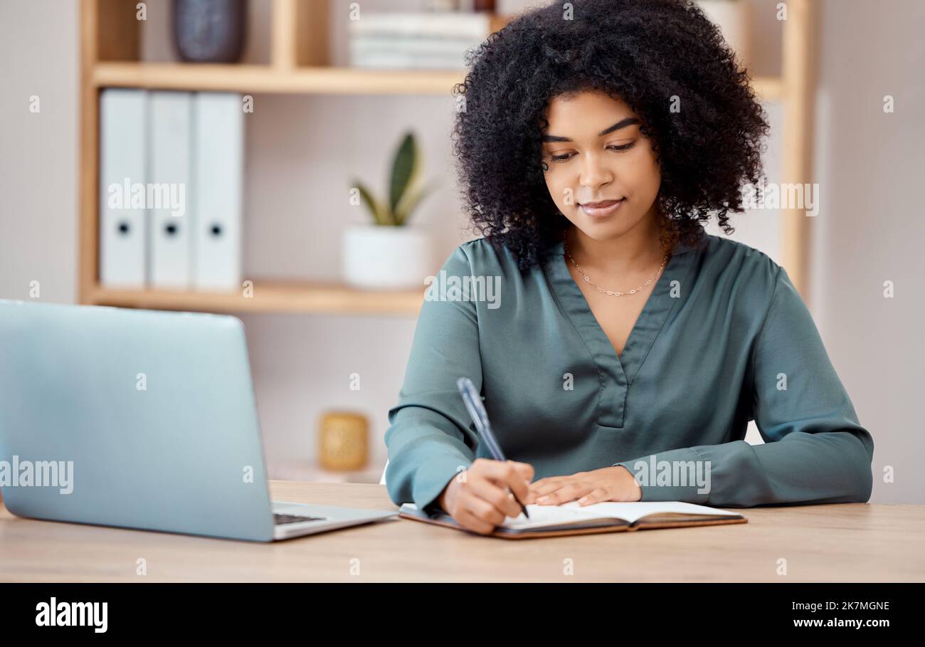 Writing, notebook and laptop with a business woman at work on her schedule at her desk in the office. Computer, pen and planning with a female Stock Photo