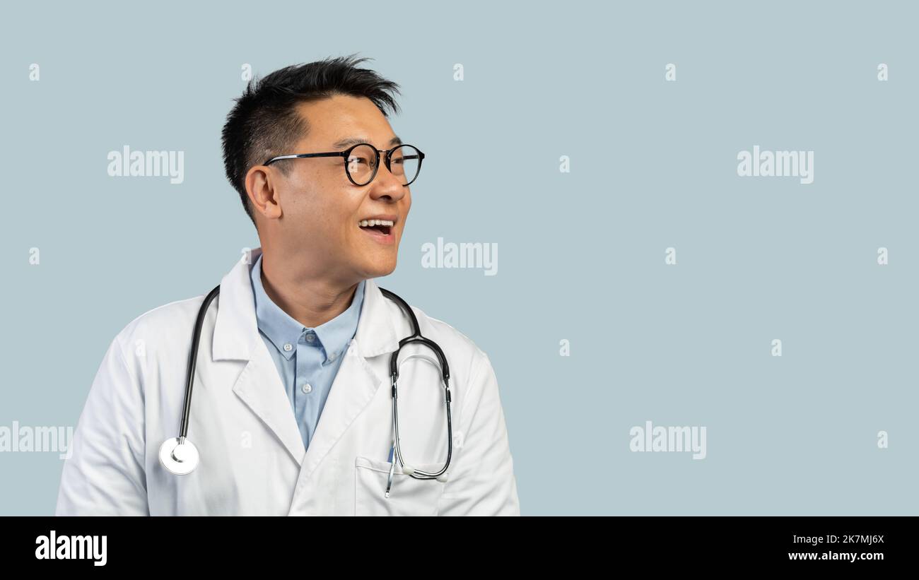 Smiling surprised middle aged chinese man doctor in white coat, glasses