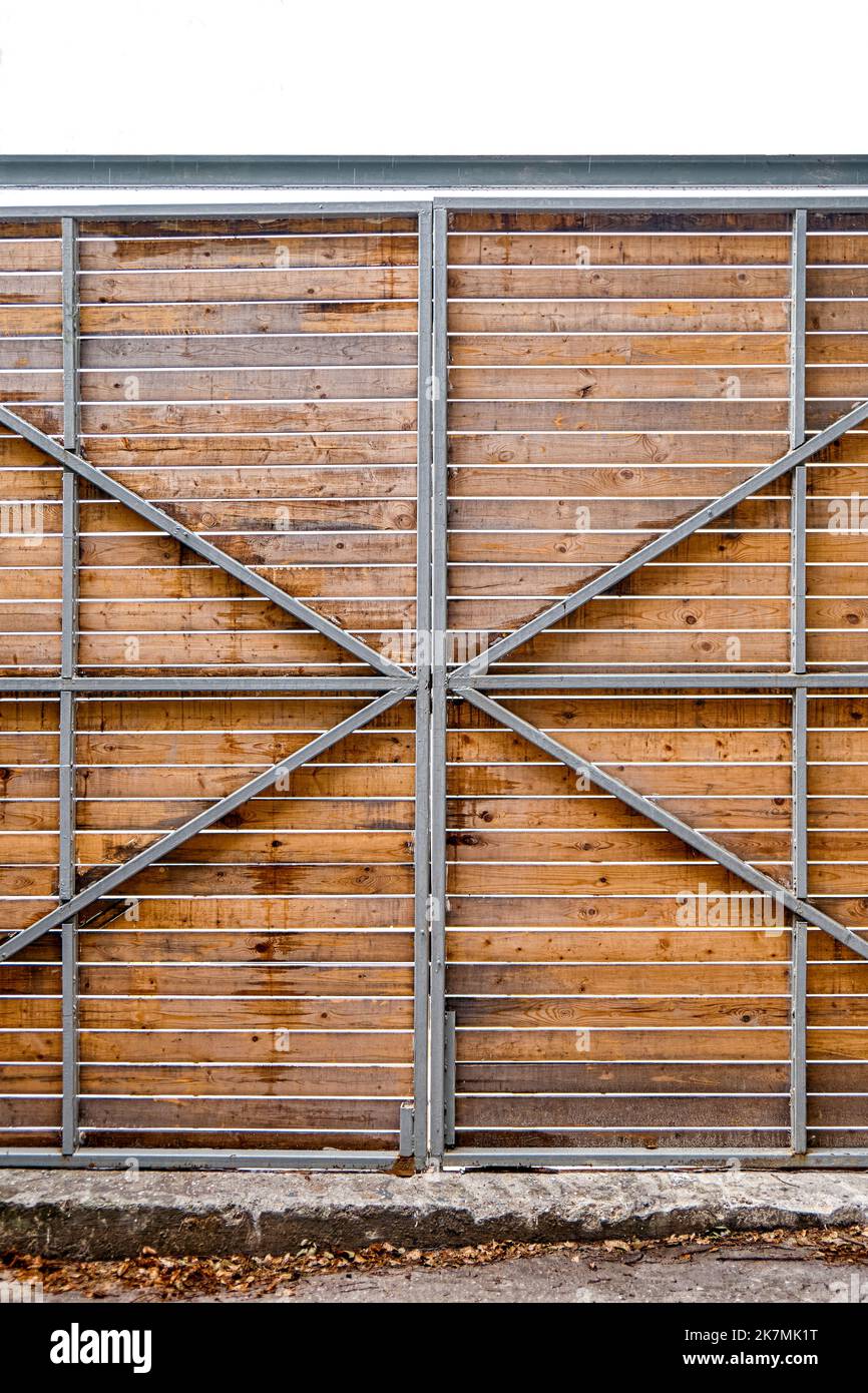 Wooden gate of horizontal boards on metal frame as background. Gate with metal frame locks view of landscape or seascape for people Stock Photo