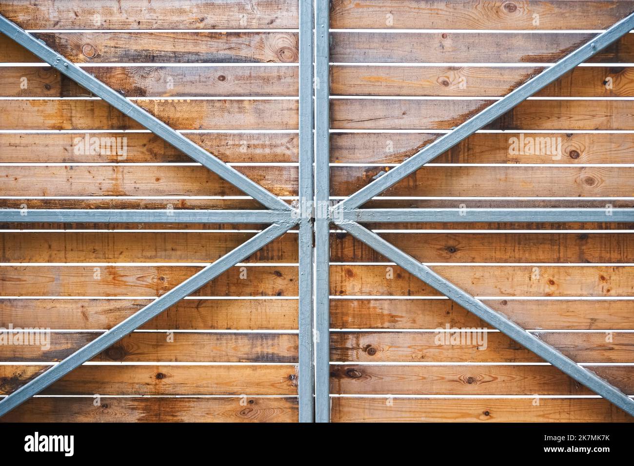 Wooden gate of horizontal boards on metal frame as background. Gate