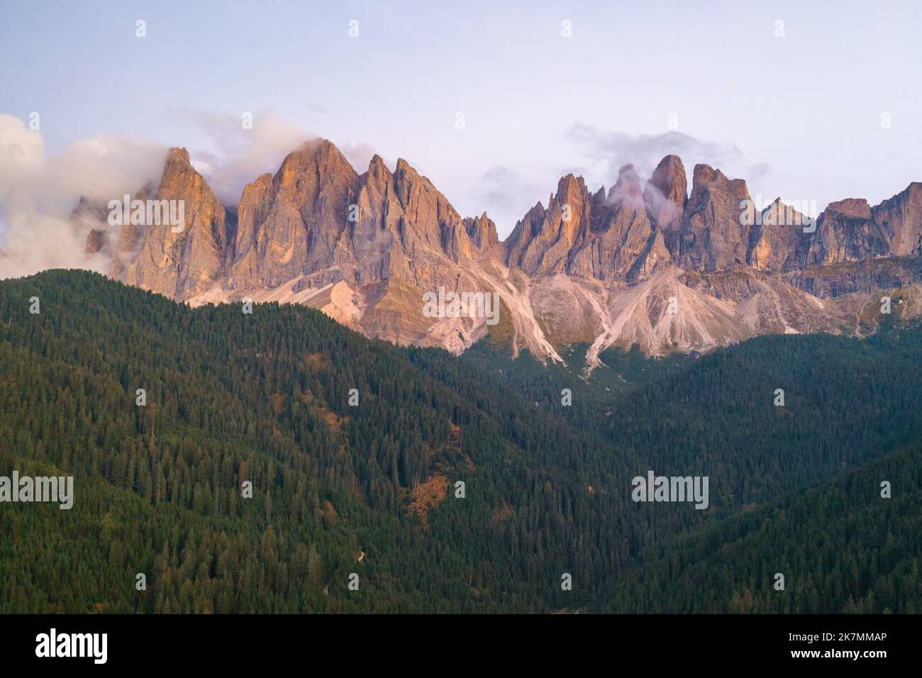 The beautiful massif of the Dolomites of Odle or Geisler group covered with clouds at sunset.  Stock Photo
