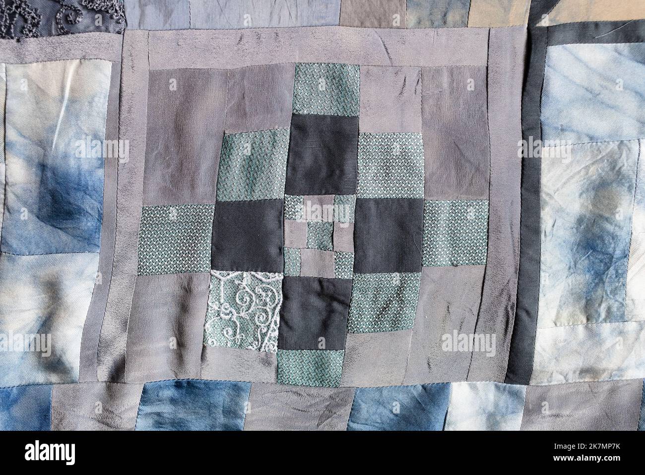 fragment of hand-crafted patchwork quilt from pieces of various silk ...