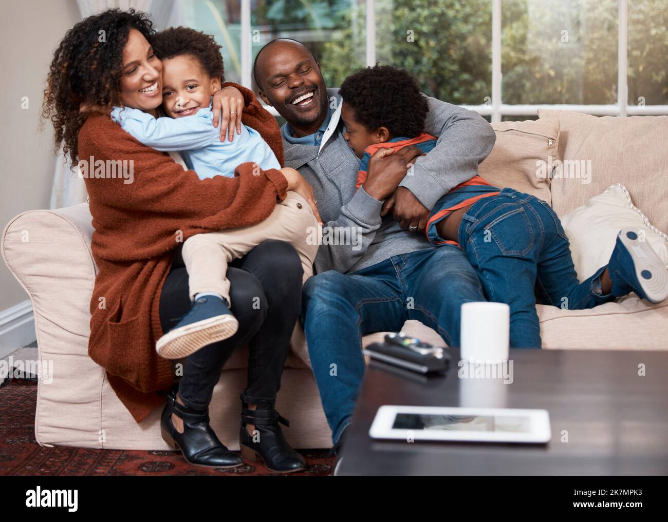 Big hugs for all. a happy family relaxing on a sofa at home. Stock Photo