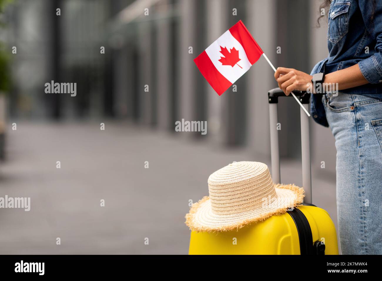 Cropped of woman traveller holding flag of Canada, going abroad Stock Photo