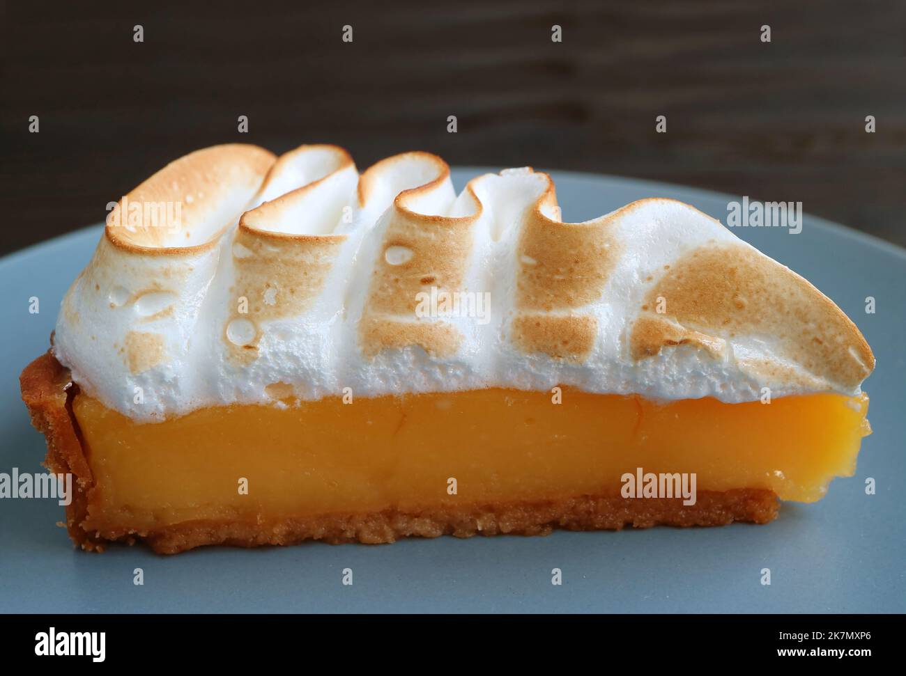 Closeup a Slice of Delectable Lemon Meringue Tart on a Blue Plate Stock Photo