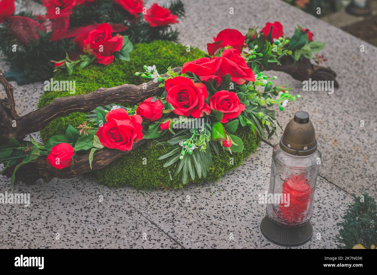 graves decorated by flowers and wreaths during all saints day on cemetery Stock Photo