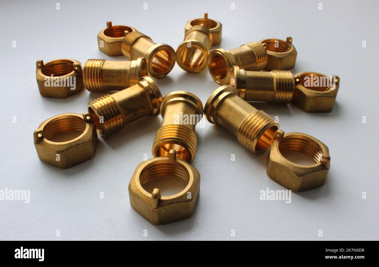 Male Brass Water Meter Fittings And Union Nuts Laid Out In The Form Of Flower On White Surface Stock Photo