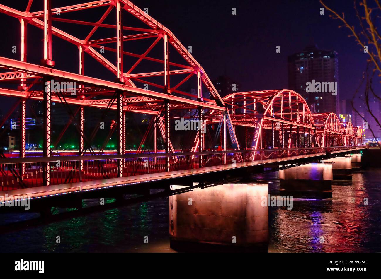 The Zhongshan Bridge over the Lanzhou Yellow River illuminated by red lights at the night Stock Photo