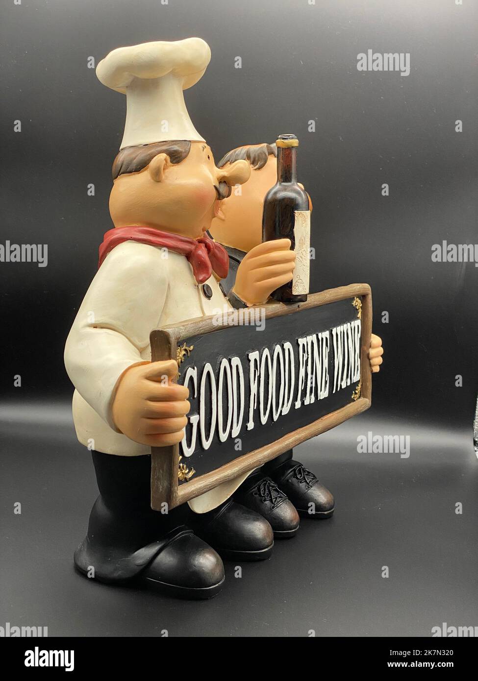 Vintage porcelain figurines of a chef and a waiter holding a wine Stock