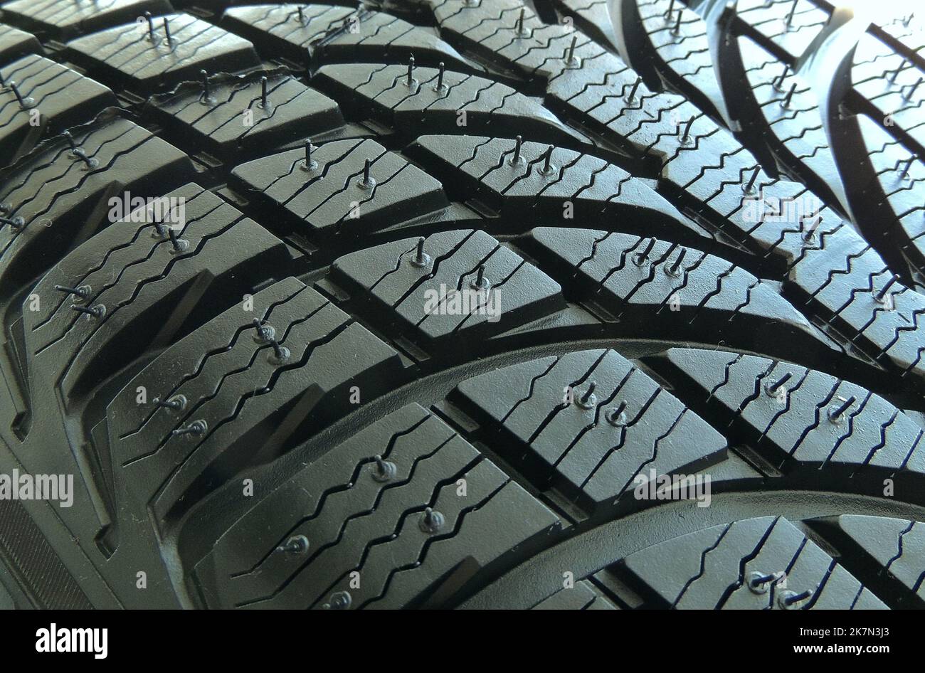 Rubber surface of new car tire with sipes and grooves close up Stock
