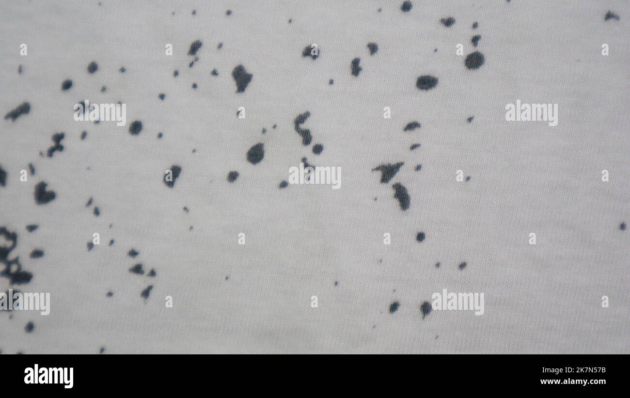 White cloth texture with black spots as background Stock Photo