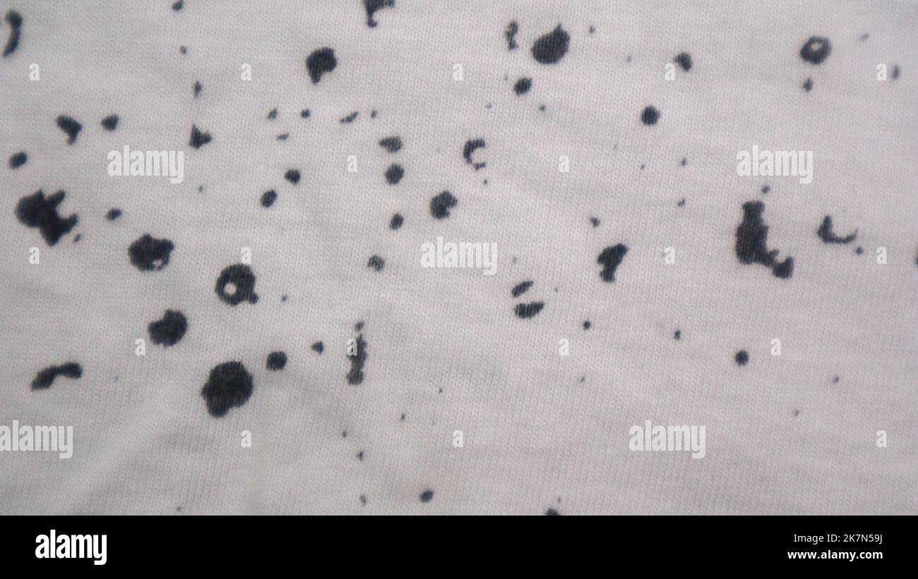 White cloth texture with black spots as background Stock Photo