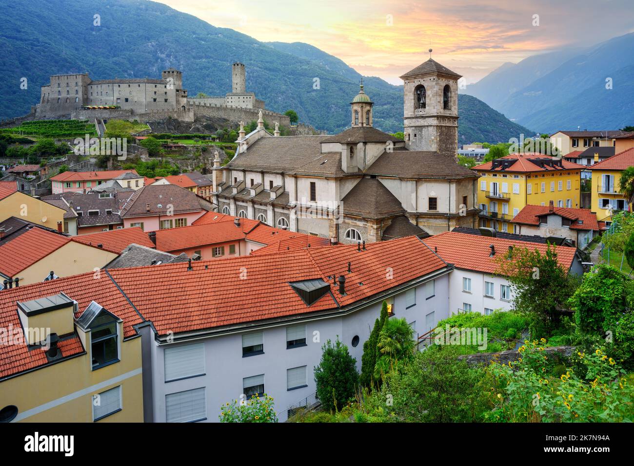 Bellinzona city, view of the historical Old town, the catholic Church, Castelgrande castle and Alps mountains on sunset, Ticino, Switzerland Stock Photo