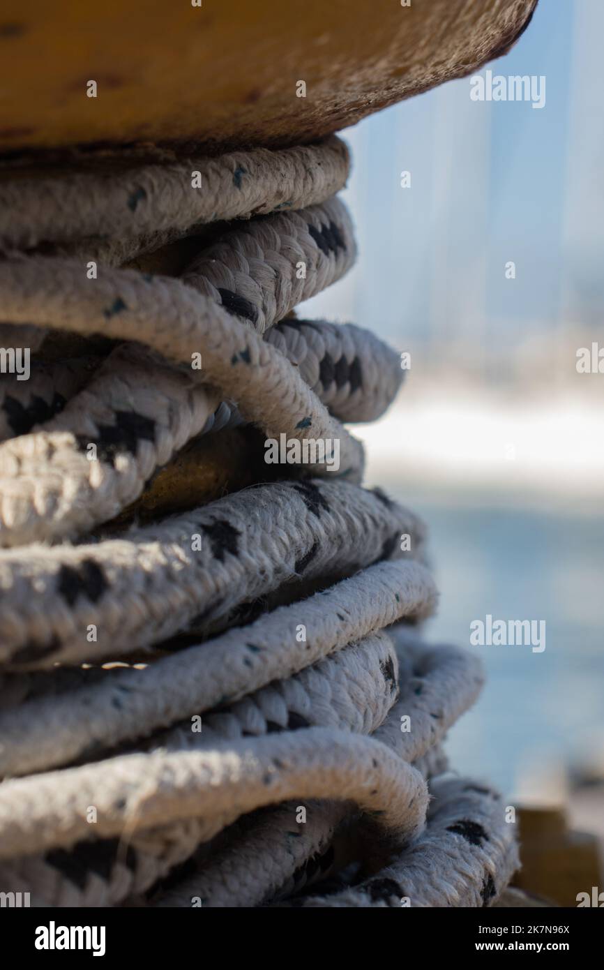 A close up of a mooring rope. Rope binding in a port. With some blurry background of boats. Stock Photo