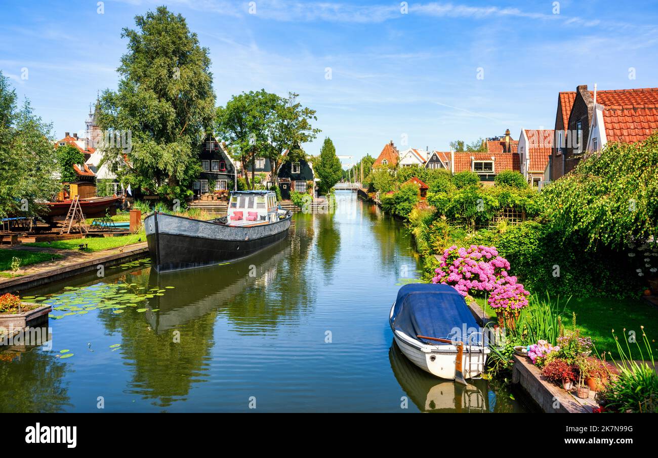 Picturesque traditional red tile roofed dutch houses along a water canal in Edam town, North Holland, Netherlands Stock Photo