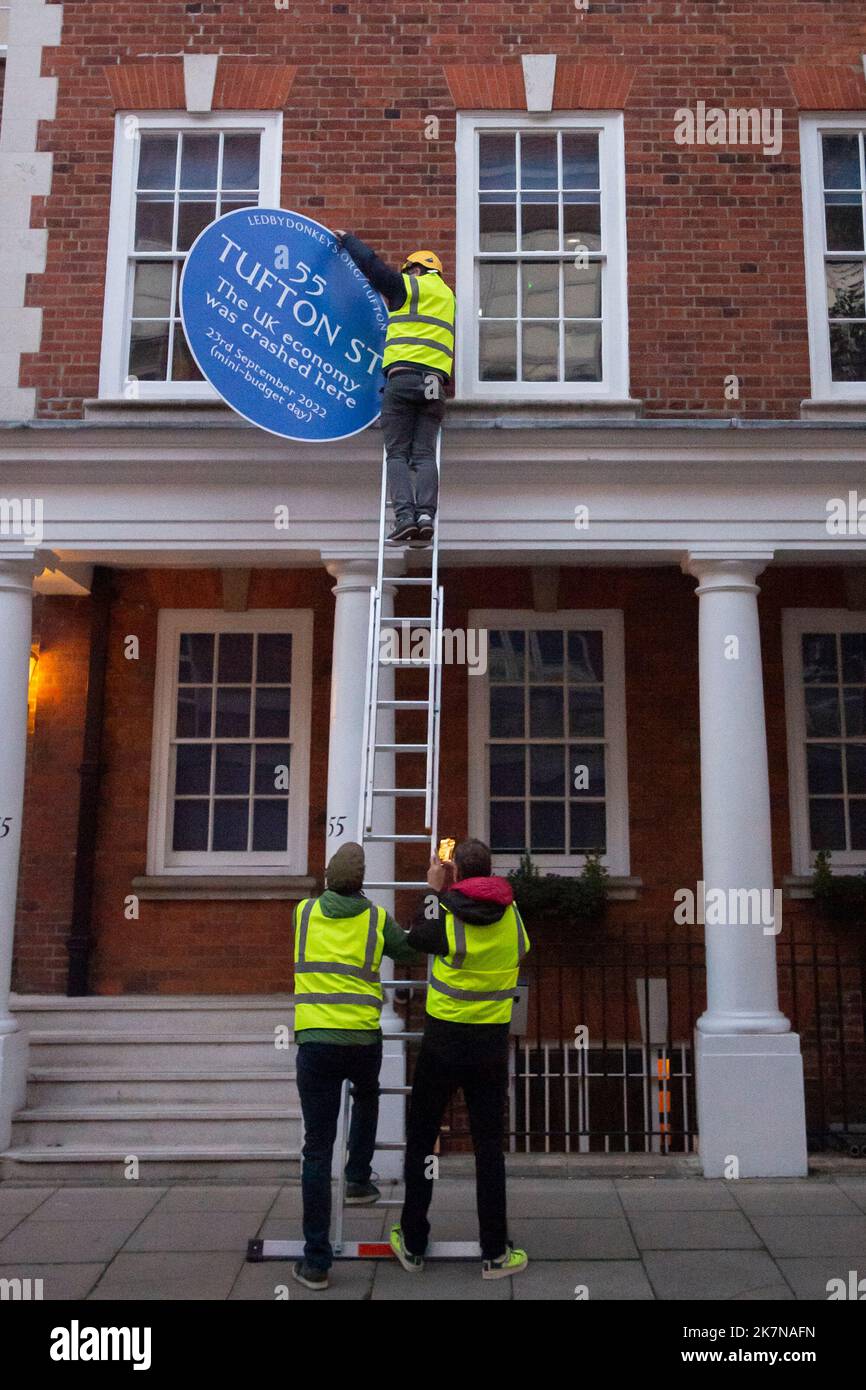 London, UK, 18 October 2022. Campaigners from Led By Donkeys fix a blue plaque to 55 Tufton Street in Westminster. The building is home to several free market groups that were instrumental in Kwarsi Kwarteng's mini budget. Credit: David Mirzoeff/Alamy Live News Stock Photo