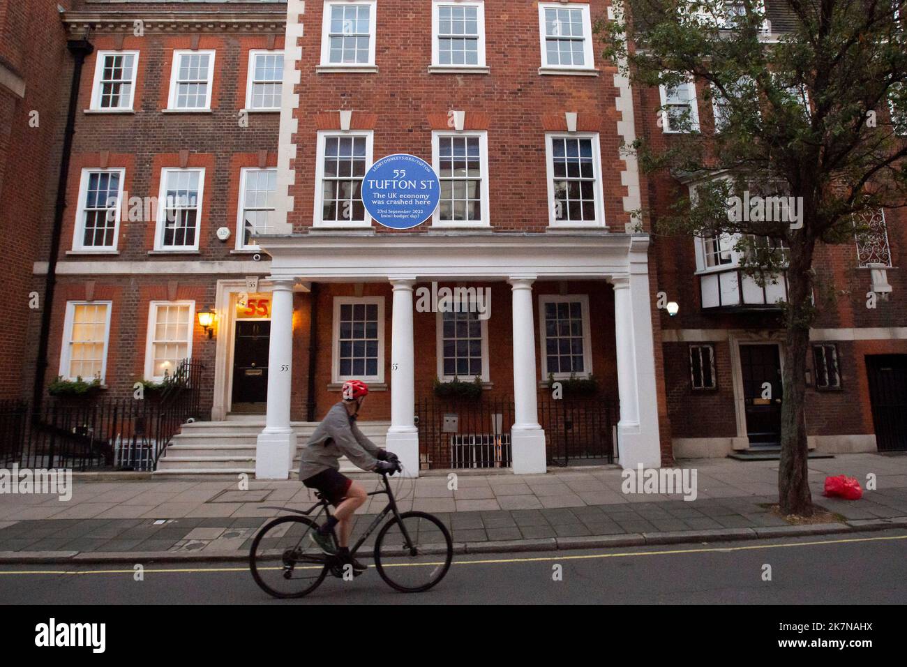 London, UK, 18 October 2022. A woman cycles past 55 Tufton Street in Westminster, where campaigners from Led By Donkeys fixed a blue plaque. The building is home to several free market groups that were instrumental in Kwarsi Kwarteng's mini budget. Credit: David Mirzoeff/Alamy Live News Stock Photo