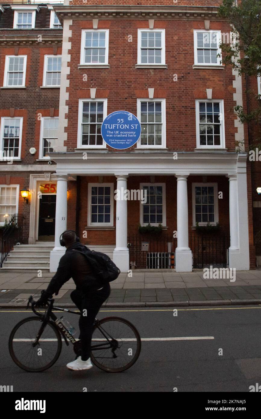 London, UK, 18 October 2022. A man cycles past 55 Tufton Street in Westminster, where campaigners from Led By Donkeys fixed a blue plaque. The building is home to several free market groups that were instrumental in Kwarsi Kwarteng's mini budget. Credit: David Mirzoeff/Alamy Live News Stock Photo