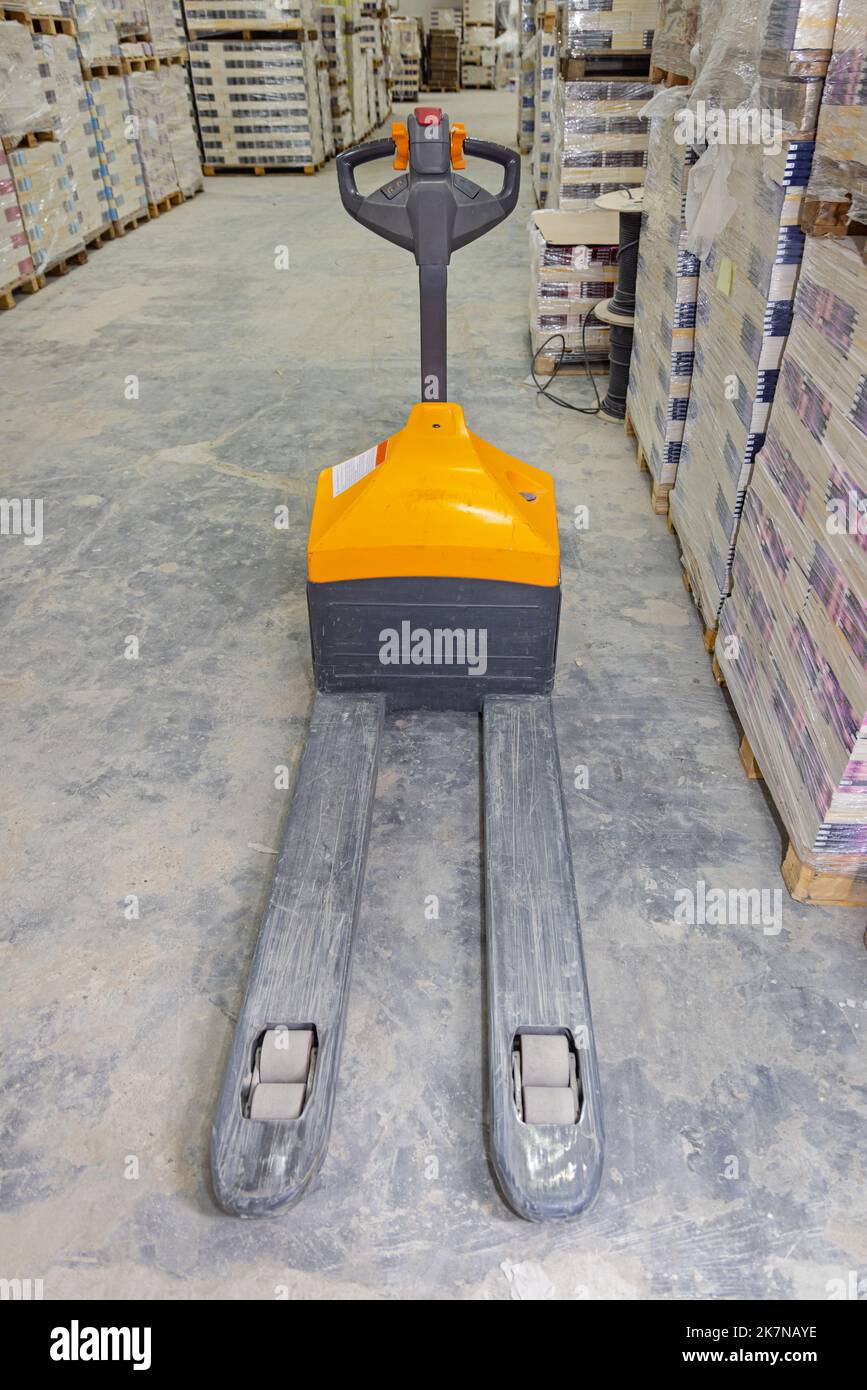 Electric Pallet Jack Forklift in Distribution Warehouse Stock Photo