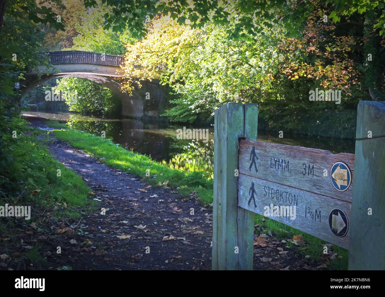 Bridgewater Canal and towpath at Grappenhall Bridge, Grappenhall Village, South Warrington, Cheshire, England, UK signpost to Lymm & Stockton Heath Stock Photo