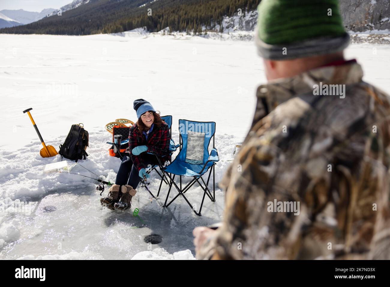 Cheerful senior woman ice fishing on frozen alpine lake Stock Photo Alamy