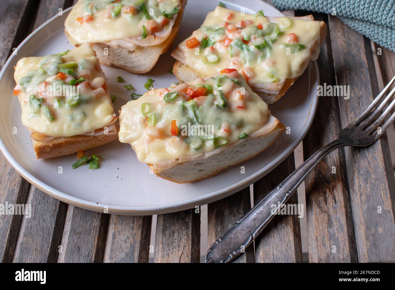 Grilled ham and cheese sandwich on french baguette with chives and bell peppers Stock Photo