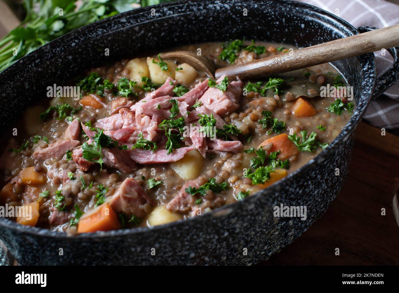Legume stew with brown lentils, vegetables, potatoes and smoked pork meat Stock Photo