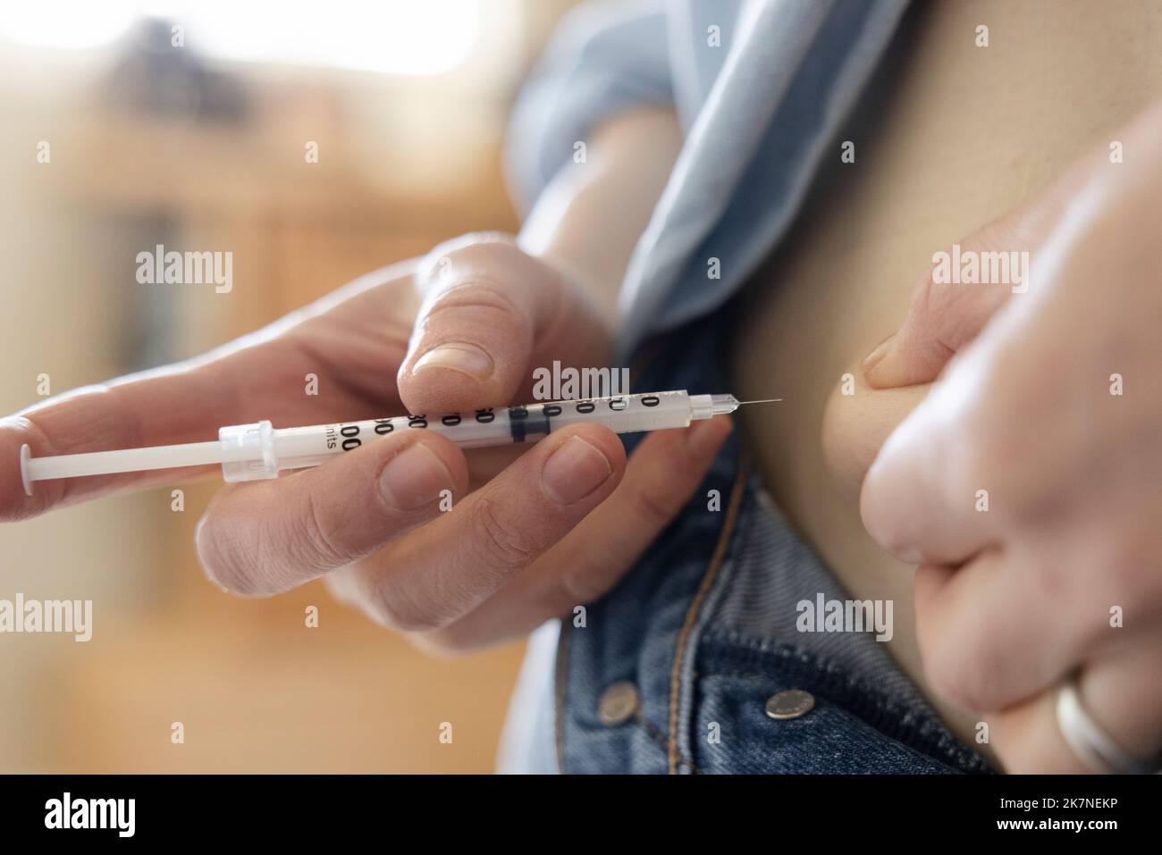 Close up woman with diabetes injecting insulin in stomach Stock Photo