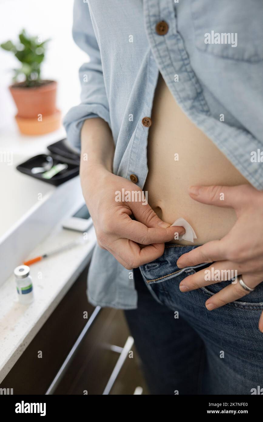 Woman with diabetes preparing stomach for insulin injection Stock Photo