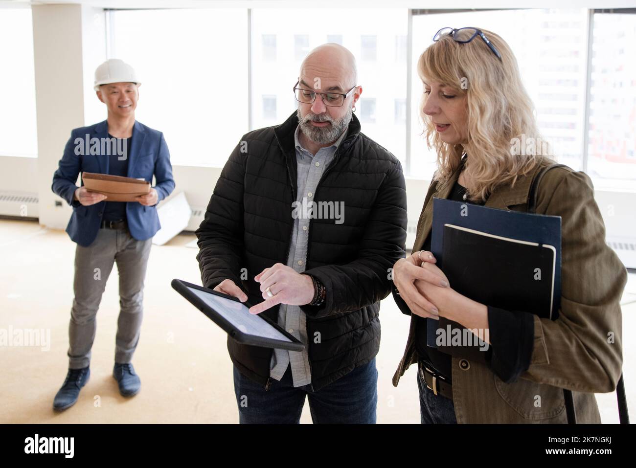 Business partners looking at office remodelling plans on tablet Stock Photo