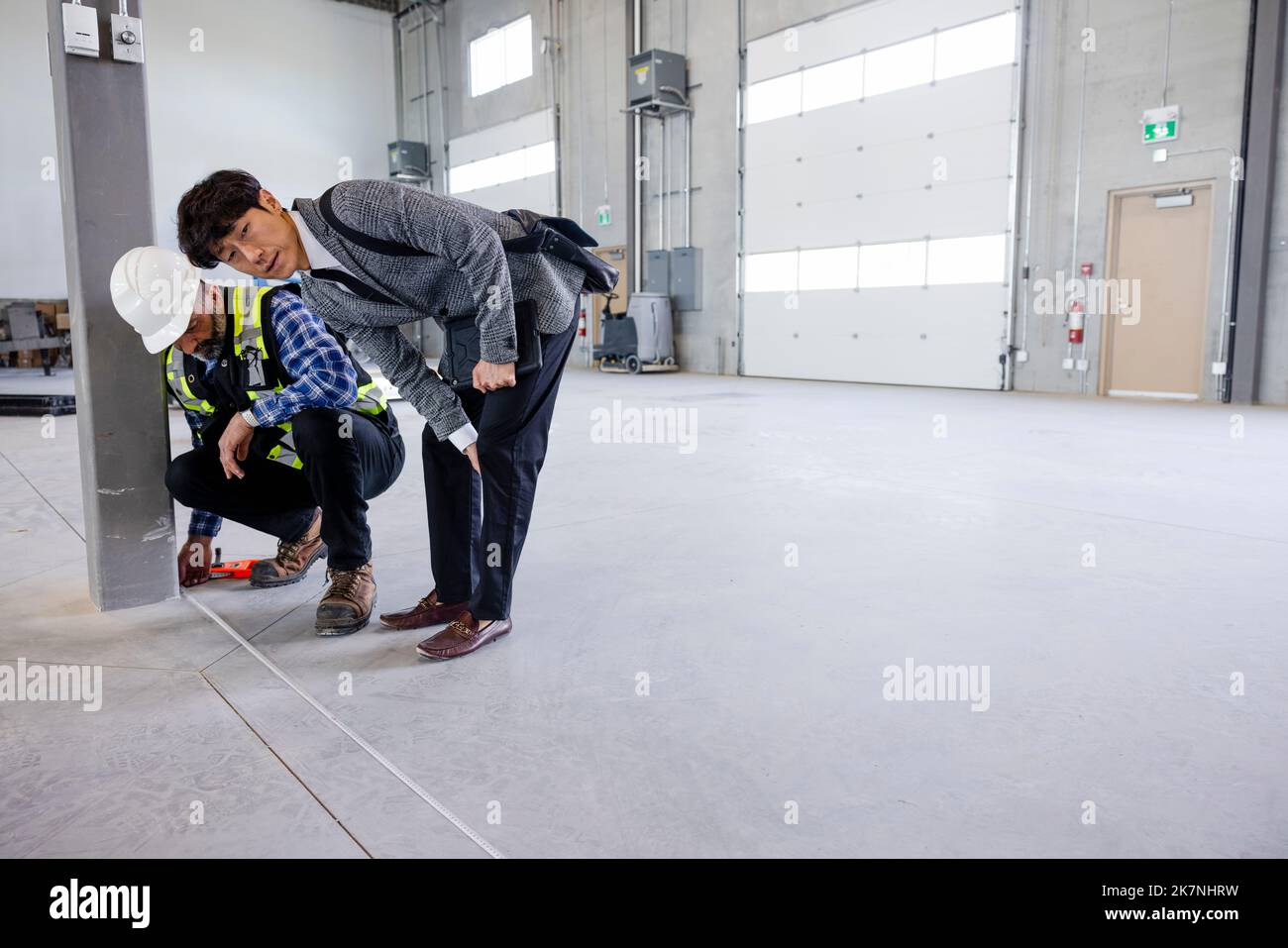 Architect and contractor measuring warehouse floor Stock Photo Alamy