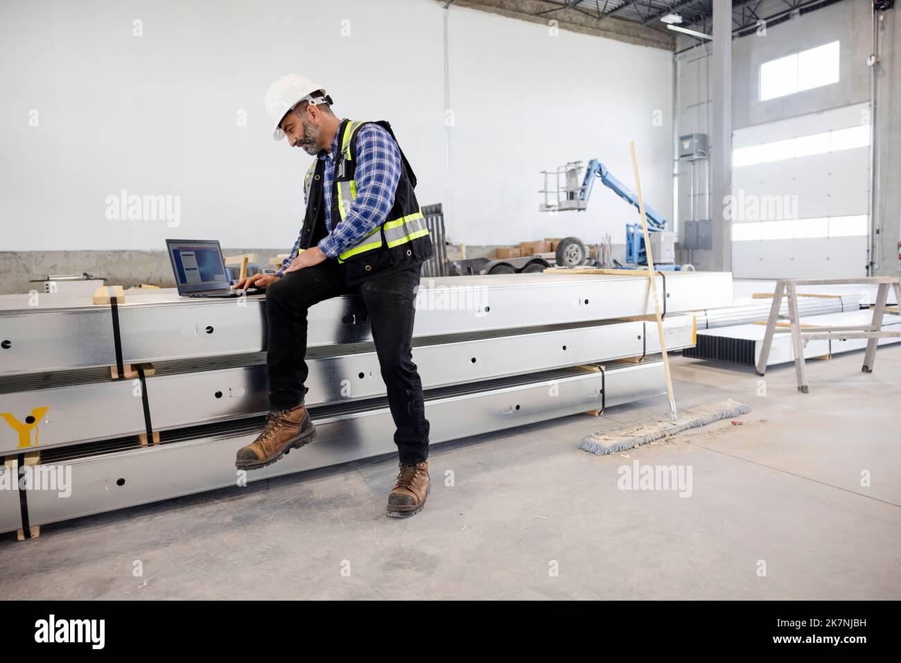Building contractor using laptop in warehouse Stock Photo Alamy