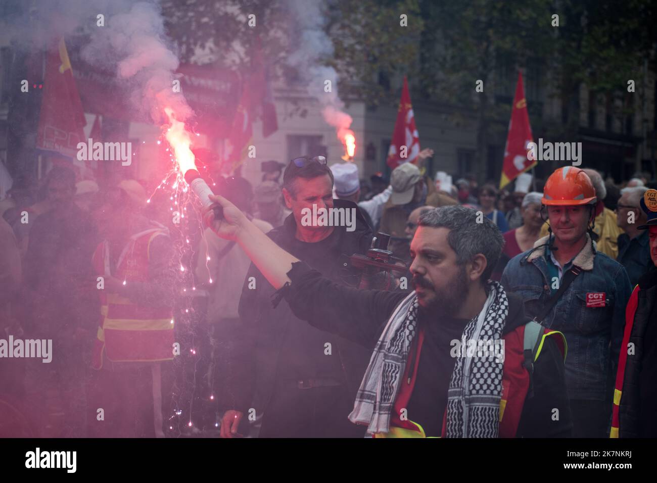 Paris, France, 18th October, 2022. Demonstrators march with a participant holding a sparkler during a national day of strike and protests for higher wages - Jacques Julien/Alamy Live News Stock Photo