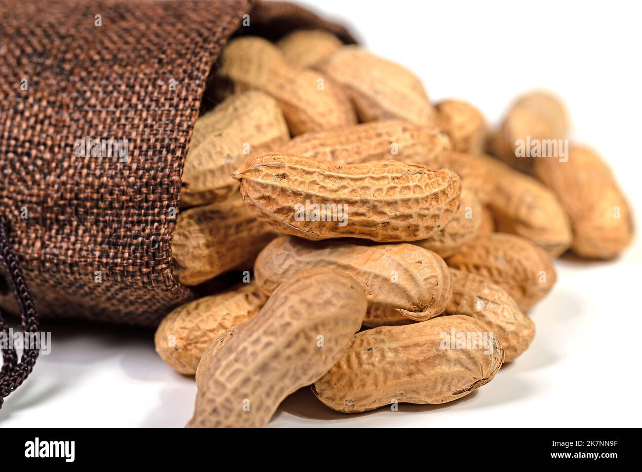 Peanuts in a jute bag against a white background Stock Photo