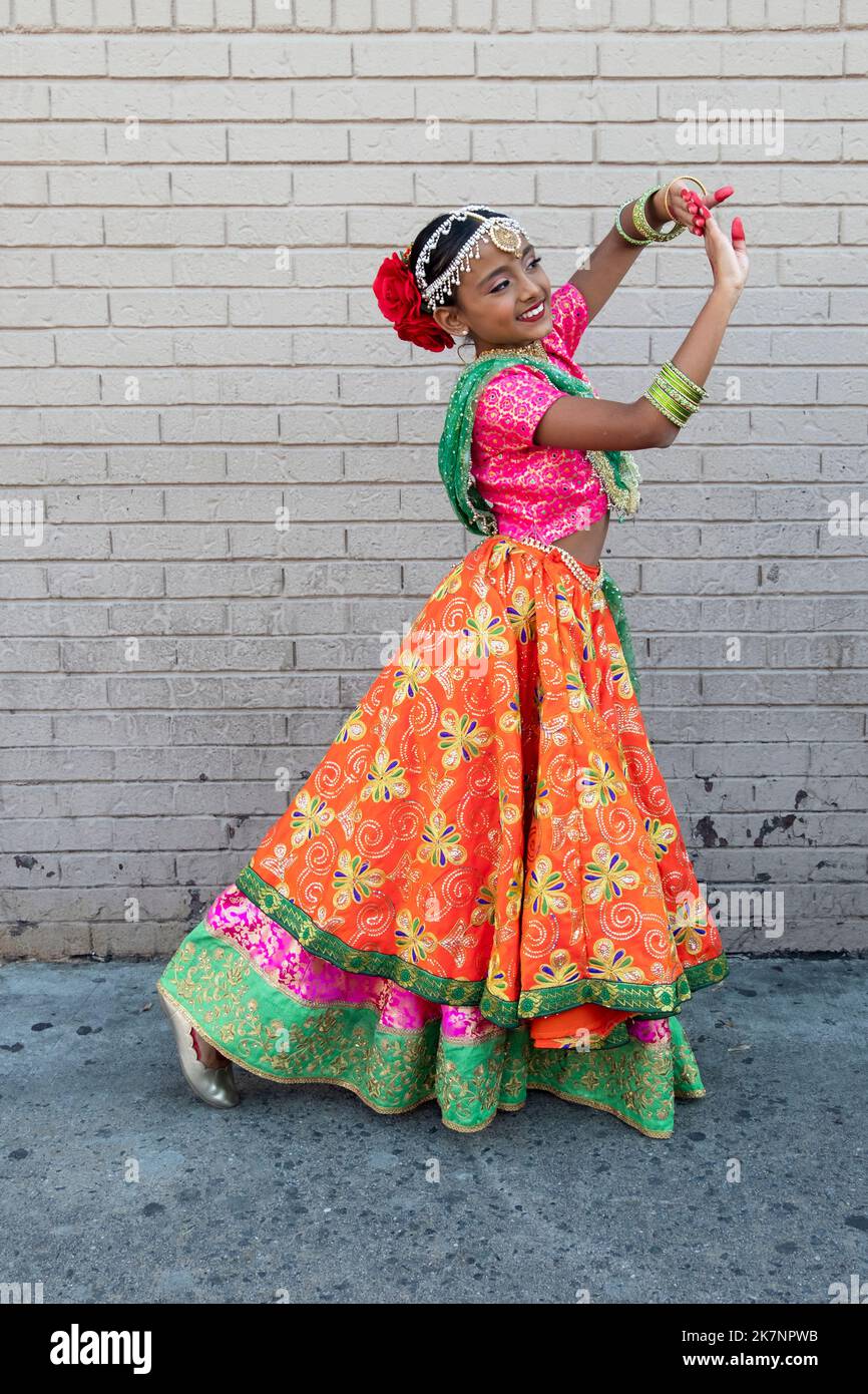 A young cute and graceful Hindu preteen dancer dressed as the goddess Lakshmi poses at Diwali 2022 in Queens, New York. Stock Photo
