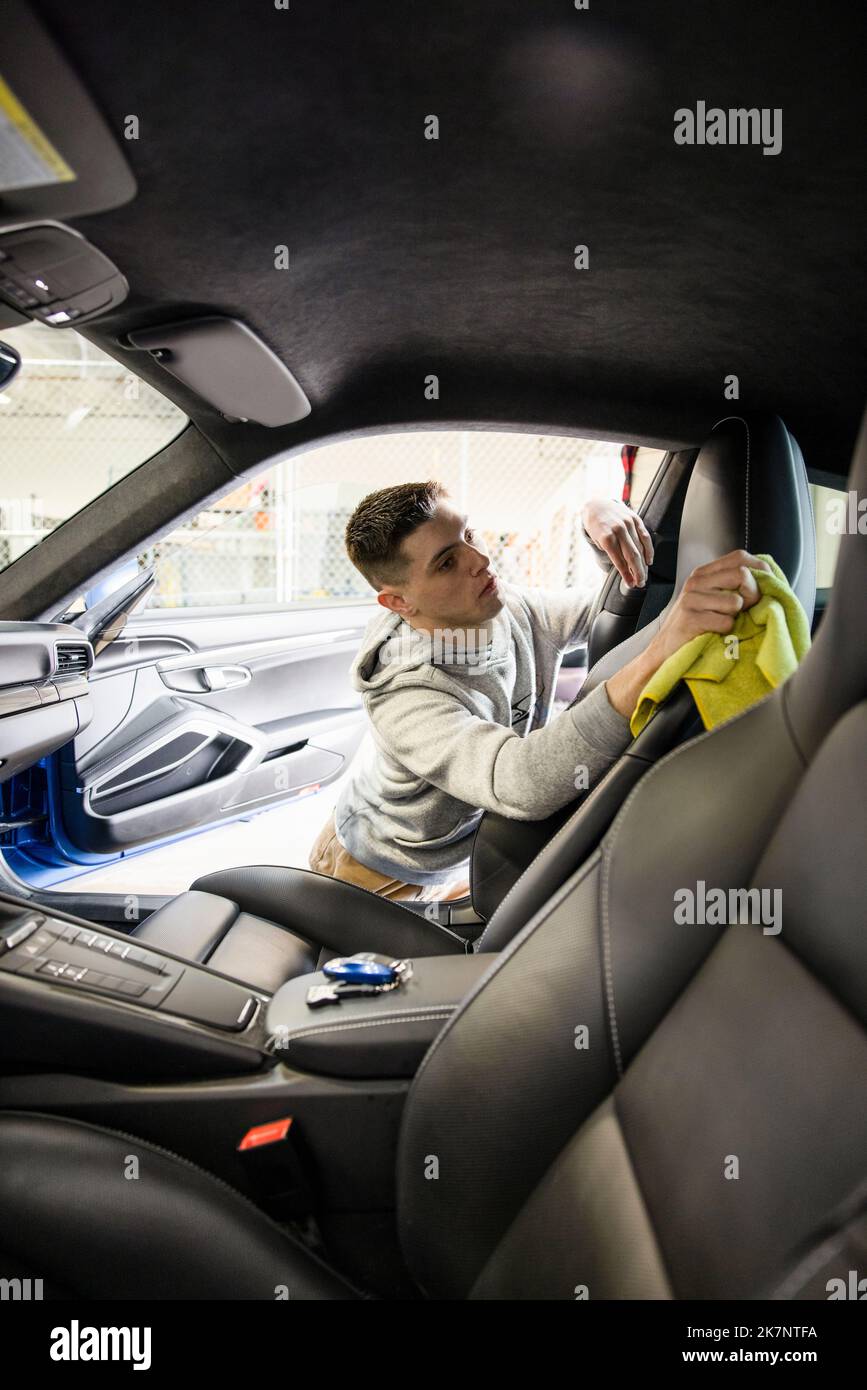 Male worker detailing inside of sports car Stock Photo