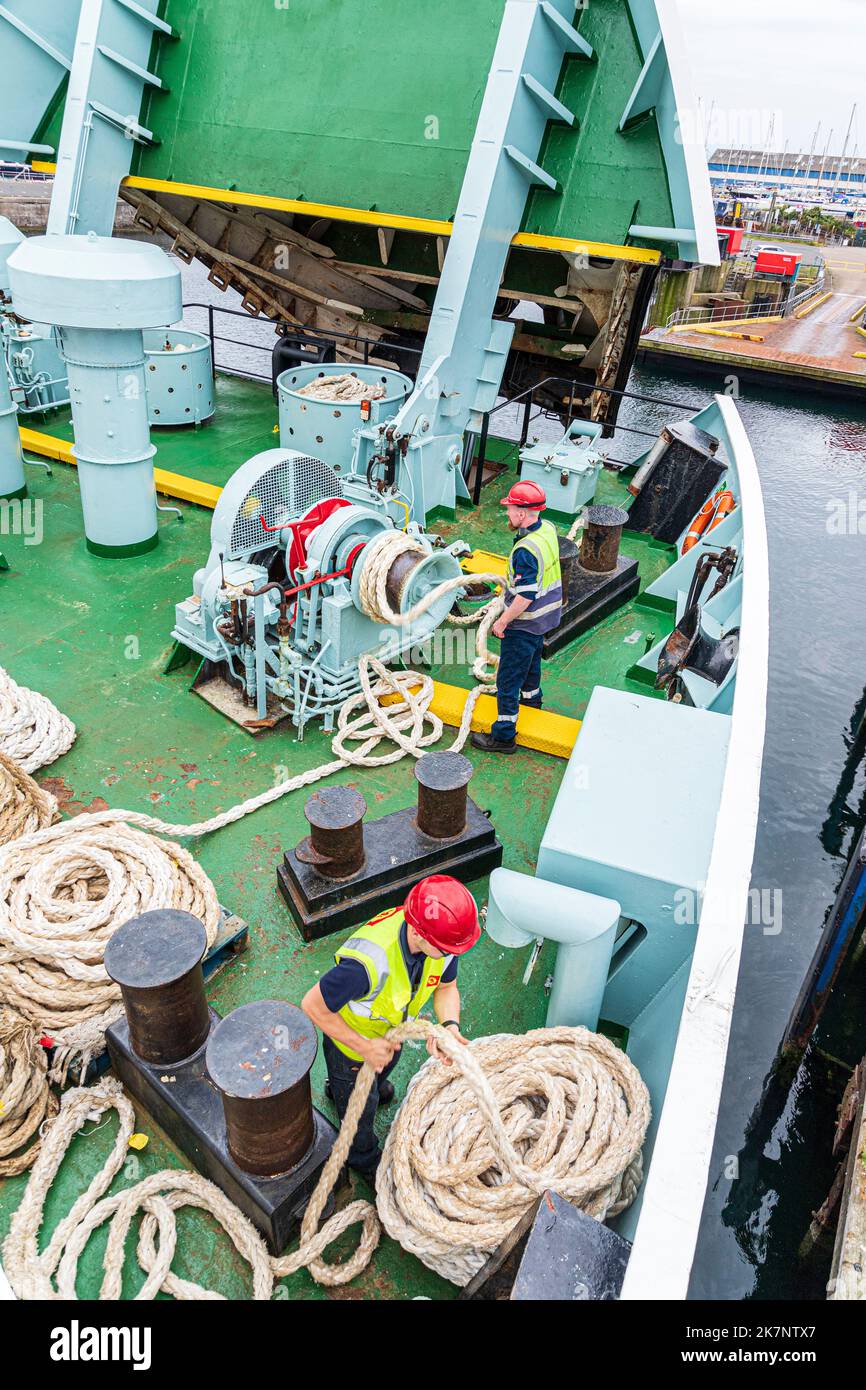 Deck hands coiling mooring ropes on the CalMac ferry Isle of Arran leaving Ardrossan, North Ayrshire, Scotland UK to cross to Campbeltown Stock Photo