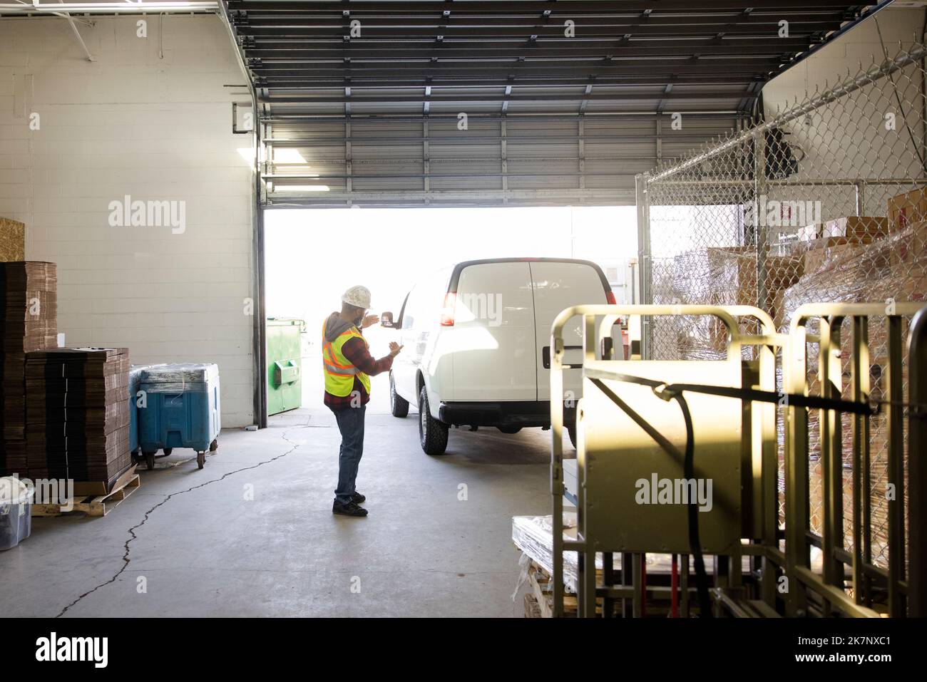 Warehouse worker guiding delivery van into loading dock Stock Photo Alamy