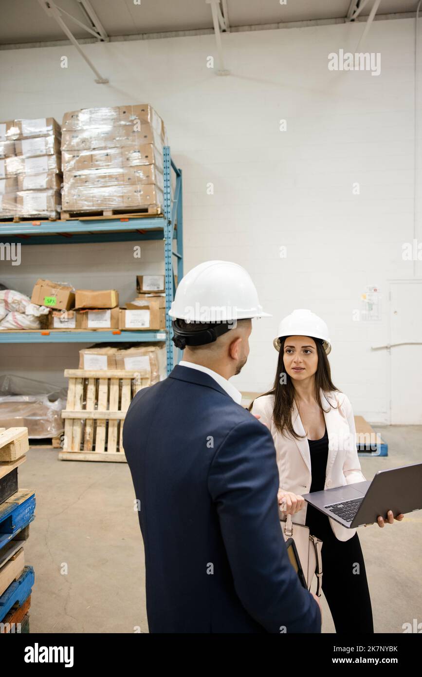 Hard hats in warehouse hires stock photography and images Alamy