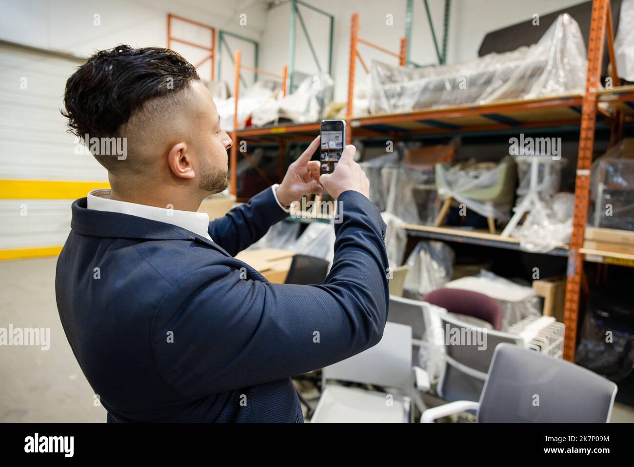 Male furniture warehouse manager using camera phone Stock Photo Alamy